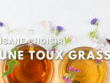 "Une tasse de tisane avec des herbes médicinales pour soulager une toux grasse, accompagnée du texte 'QUELTE TISANECHOISIR POUR UNE TOUX GRASSE'."